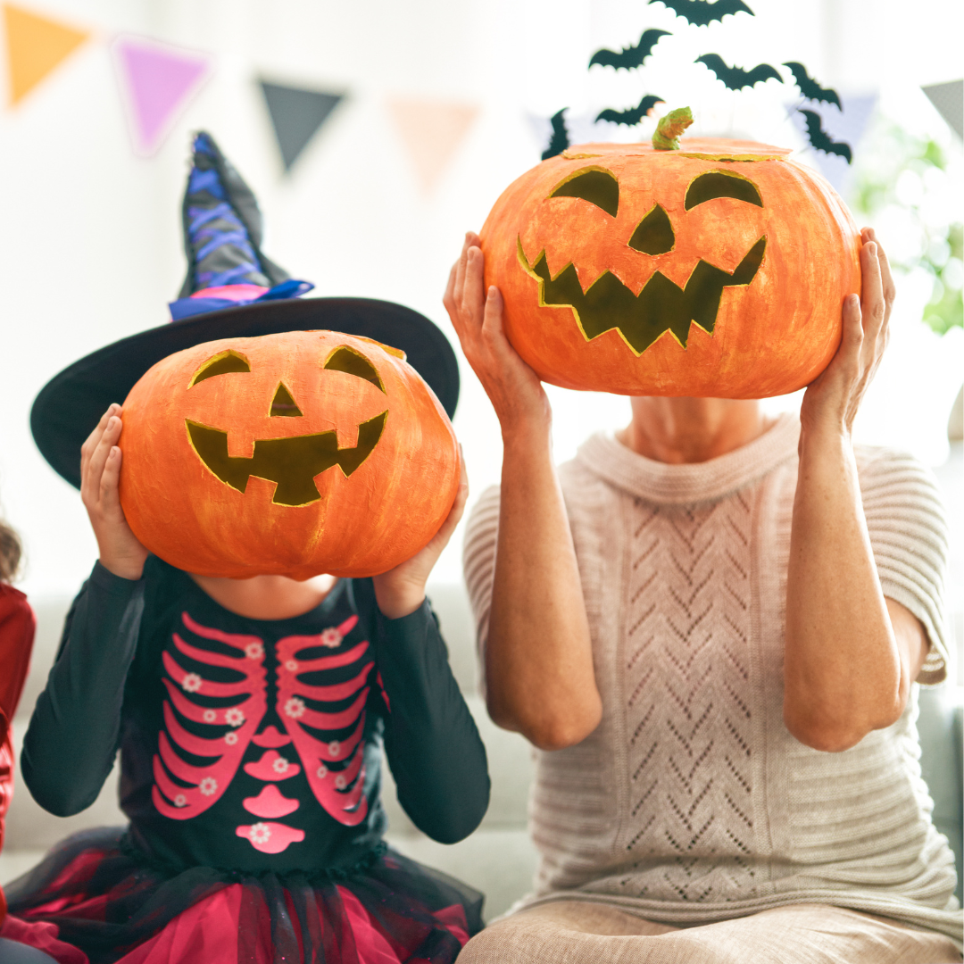 two people dressed for halloween with pumpkins in front of their faces