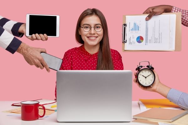 smiling-beautiful-woman-red-shirt-sits-front-opened-laptop-computer