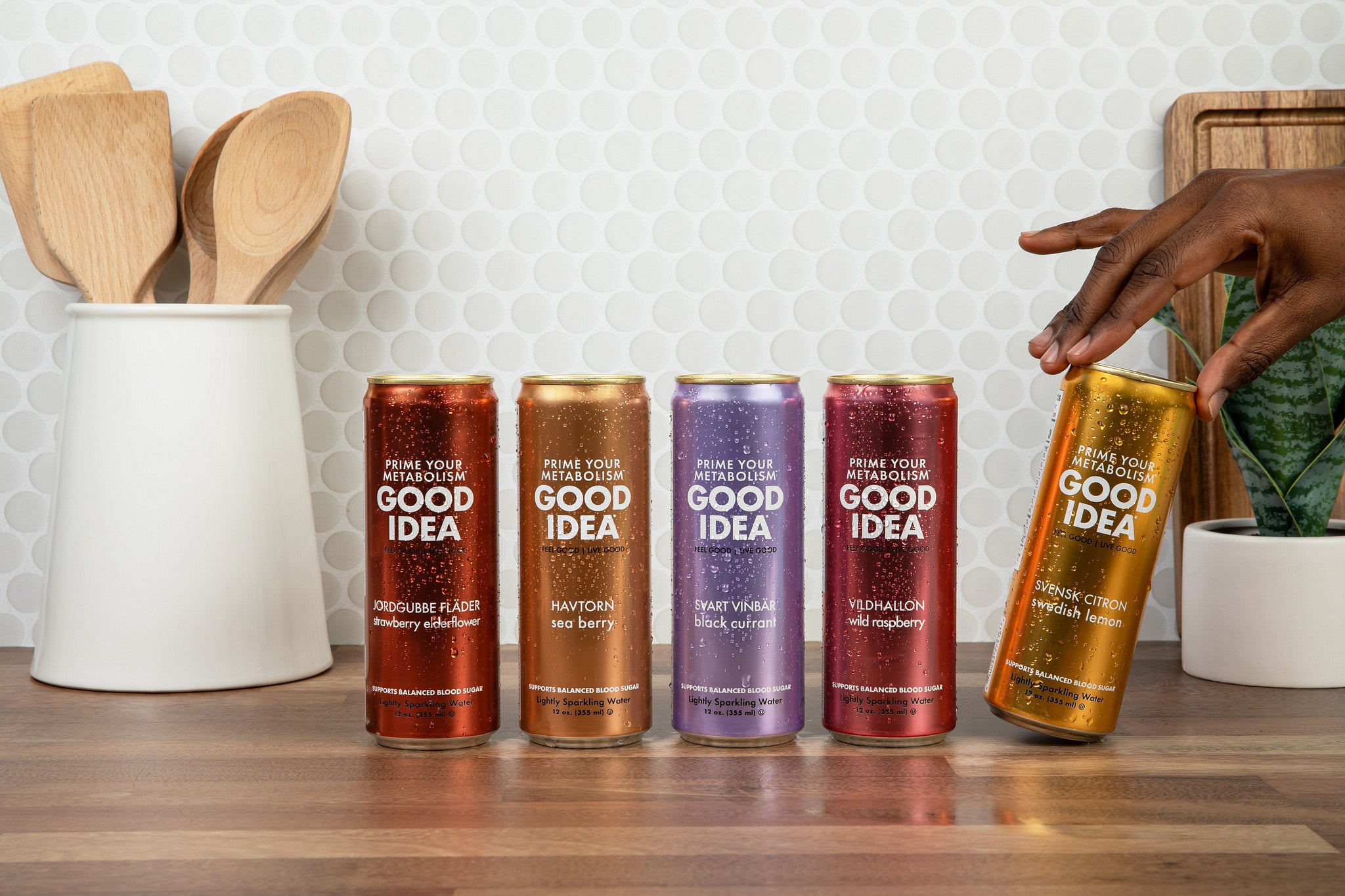 All five Good Idea flavors on a kitchen counter, with a person picking up the Swedish Lemon flavor