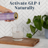 Person pouring Good Idea sparkling water into a glass on a wooden tray with a plant in the background, with text that reads “Activate GLP‑1 Naturally”.