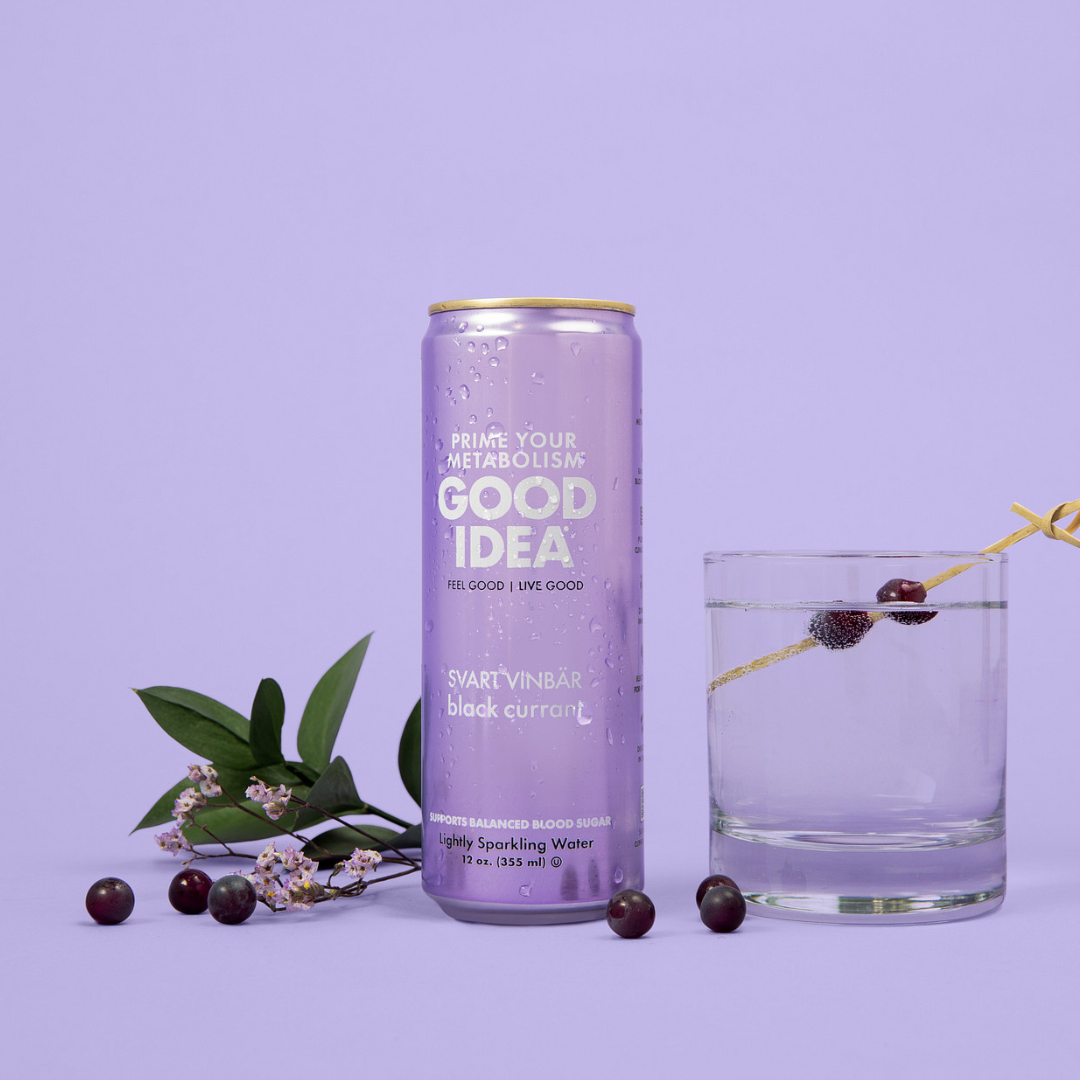 GOOD IDEA Black Currant sparkling water next to a glass of sparkling water on a purple background