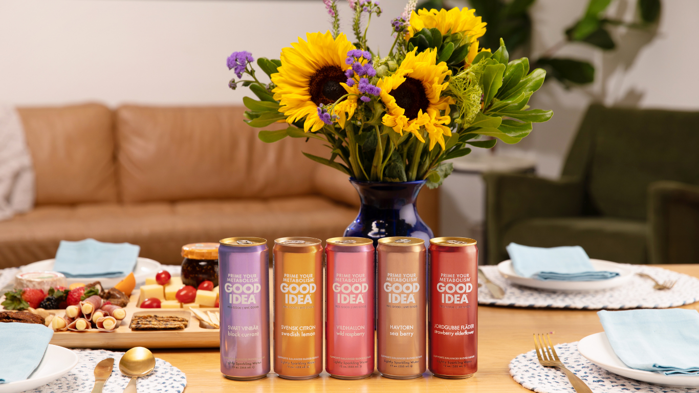 Fall theme all five GOOD IDEA flavors on a dinner table with food in the background and a bouquet of sunflowers on the table