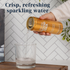 Person pouring a can of Good Idea sparkling water into a glass, with text on the image that reads “crisp, refreshing sparkling water.”
