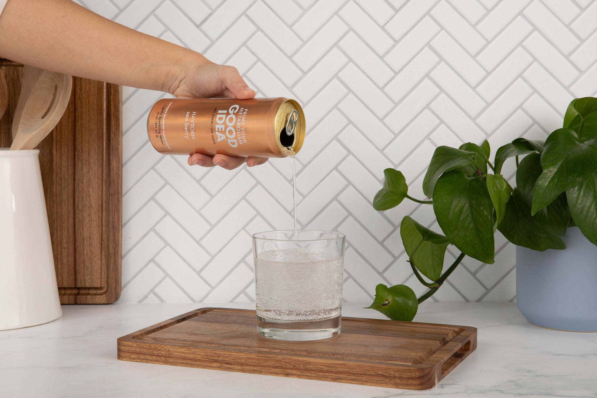 Person pouring the Sea Berry flavor of Good Idea sparkling water into a glass