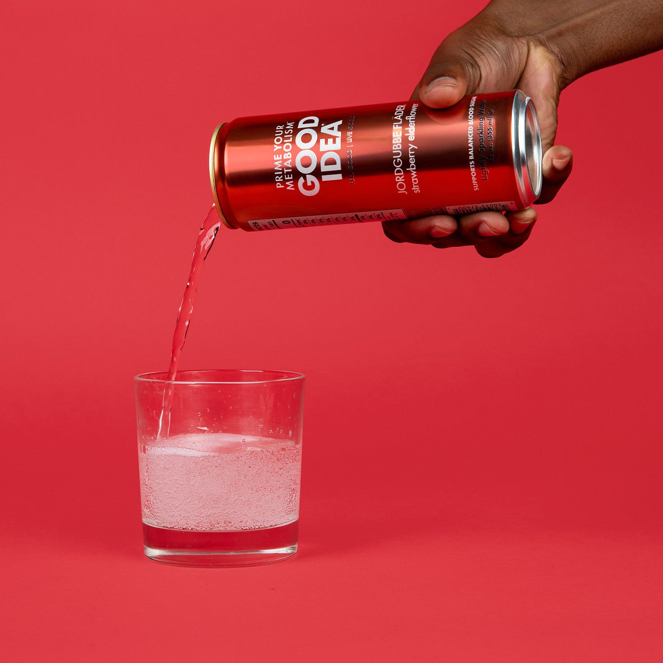 Person pouring a can of Good Idea Strawberry Elderflower sparkling water into a glass